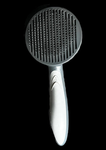 De-shedding dog brush showing rubber handle, stainless steel needles and ergonomic handle