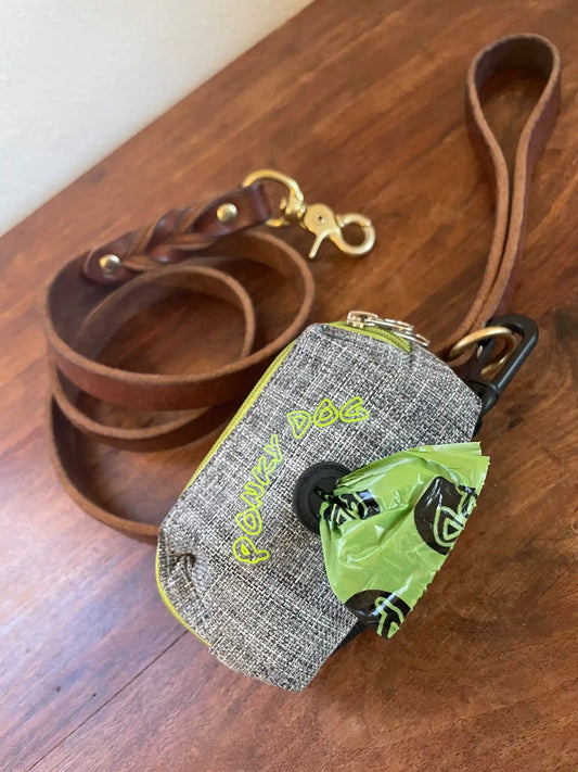Ponky Dog Poo Bag Dispense and Extra Strong Poo Bags attached to brown leather lead on a wooden surface